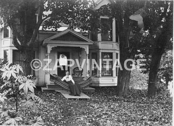 Vintage 1900s Girl Sitting On Hammock In Front Of House Maine ME. Photo #1952